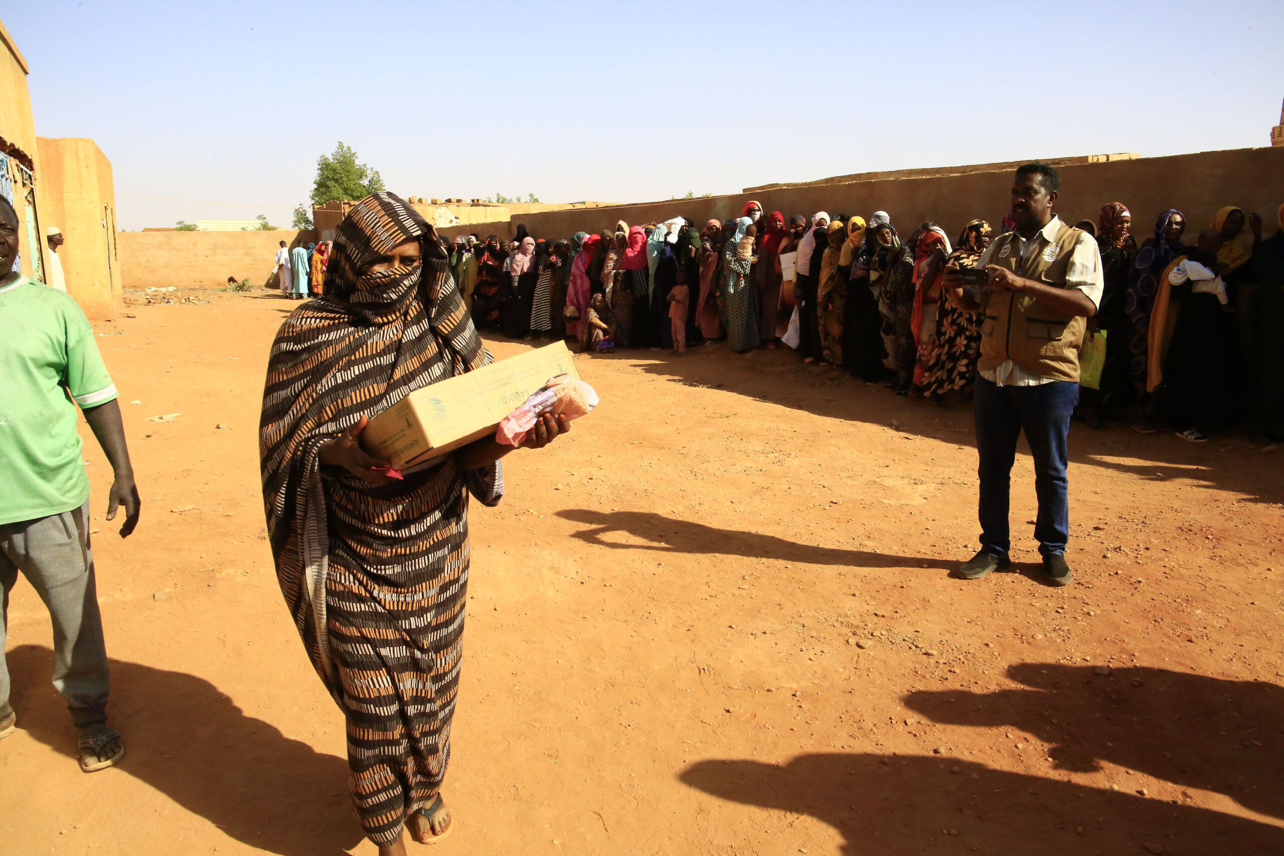 امرأة تحمل مساعدات غذائية 