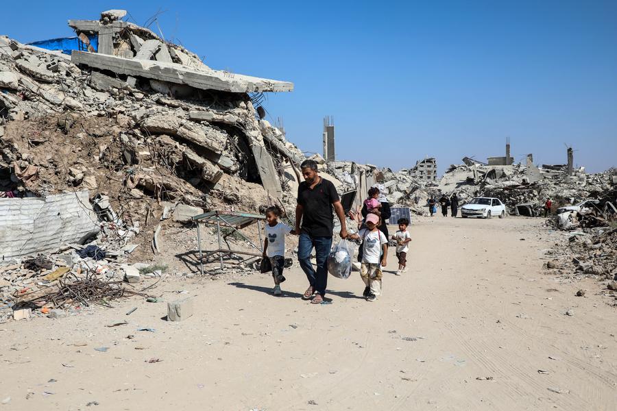 فلسطينيون بمخيم للنازحين في حي الزيتون جنوب شرقي مدينة غزة يحملون أمتعتهم ويغادرون المخيم، يوم 18 يوليو 2026. (شينخوا)